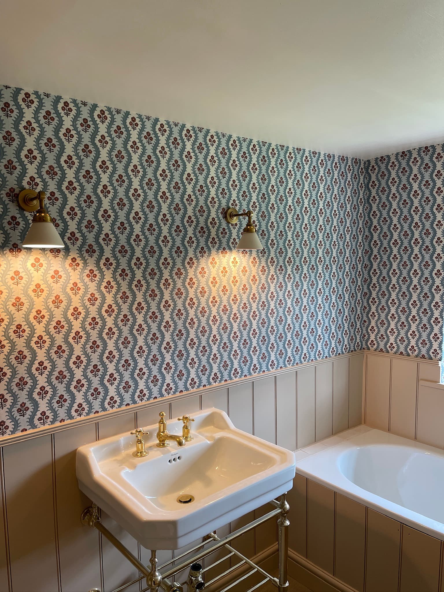 Room with painted wall panelling below the dado rail and a traditional basin with brass taps